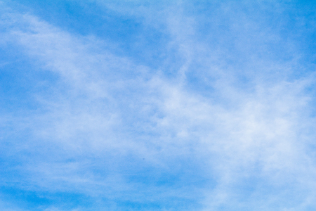 Clear blue sky background with white clouds.の写真素材