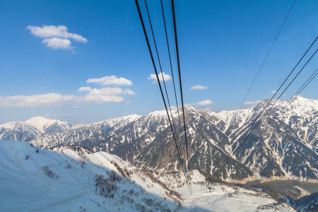 Cable car line going to Tateyama Kurobe Alpine Route on the snow mountains wall , Beautiful landscape the view on Tateyama Japanese Alps with blue sky background. Toyama city, Japanの写真素材