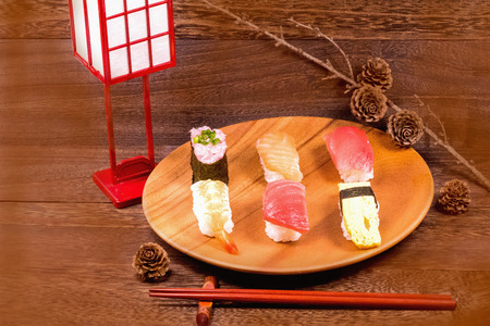 Japanese food ,sushi with chopsticks on wooden table wall background .の写真素材