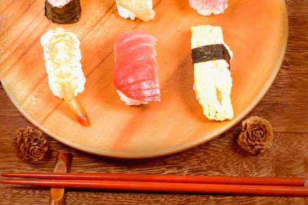 Japanese food ,sushi with chopsticks on wooden table wall background .の写真素材