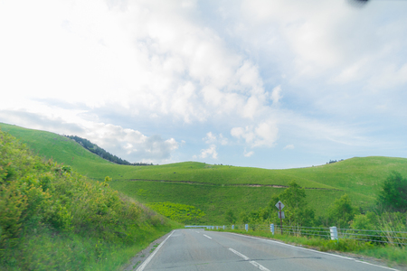 Beautiful  landscape view of  a country road and green grass with  blue sky  background of Utsukushigahara park is  one of the most important and popular natural place in Nagano Prefecture , Japan.の写真素材