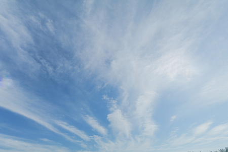 Clear blue sky background with white clouds.の写真素材