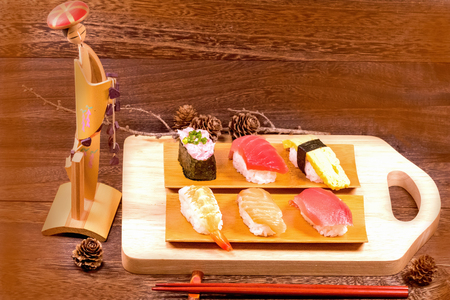 Japanese food ,sushi with chopsticks on wooden table wall background .の写真素材