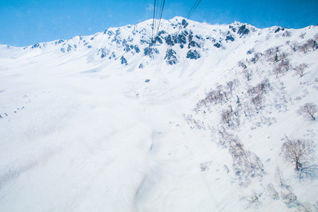 The snow mountains  of Tateyama Kurobe alpine  with blue sky  background is  one of the most important and popular natural place in Toyama Prefecture, Japan.の写真素材