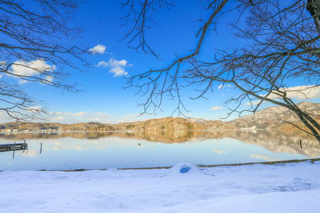 Beautiful fresh snow in winter around the mountains  Lake ,and tree  with blue sky  background, Nagano Prefecture, Japan.の写真素材