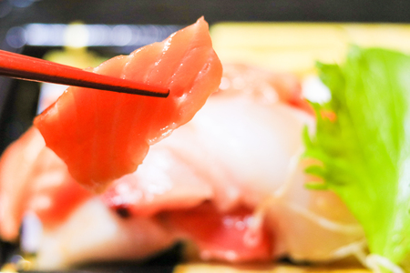 Japanese food,sashimi with chopsticks.の写真素材