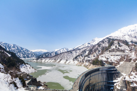 Kurobe Dam on the Kurobe River and beautiful landscape Tateyama Kurobe Alpine Route the snow mountains  with blue sky background in Toyama Prefecture, Japan.の写真素材
