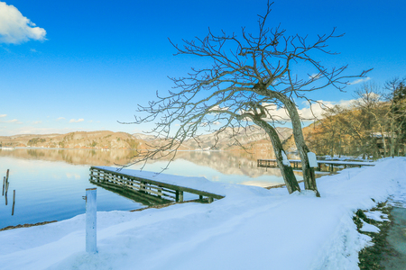 Beautiful fresh snow in winter around the mountains  Lake ,and tree  with blue sky  background, Nagano Prefecture, Japan.の写真素材