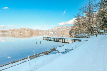 Beautiful fresh snow in winter around the mountains  Lake ,and tree  with blue sky  background, Nagano Prefecture, Japan.の写真素材