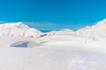 The snow mountains wall of Tateyama Kurobe alpine or japan alps in sunshine day with  blue sky background is one of the most important and popular natural place in Toyama Prefecture, Japan.の写真素材