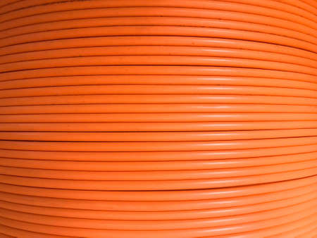Fiber optic cables are arranged in rolls, Orange background with Fiber optic cables