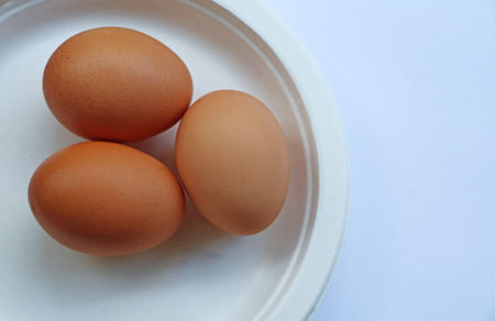 Three eggs in dish on white background. Top view (eggs, egg)