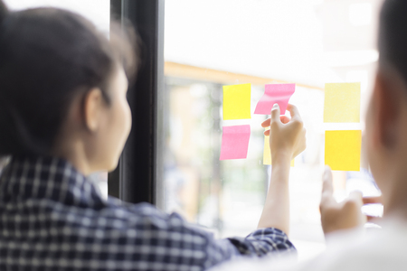 business people having a meeting in office, business people post it notes in glass wall, soft focusの写真素材