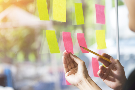 business people having a meeting in office, business people post it notes in glass wall, soft focusの写真素材