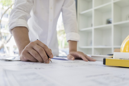 Engineer sketching architectural project on blueprintの写真素材