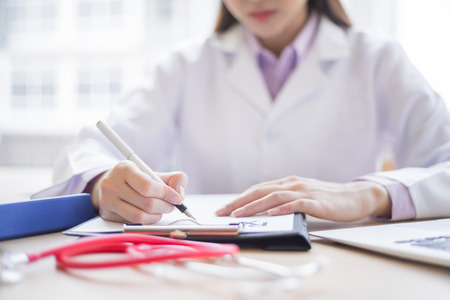 doctor is writing prescription in paper to patient, medical conceptの写真素材