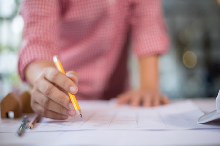 Engineer sketching architectural project on blueprint, engineering concept, architectural concept