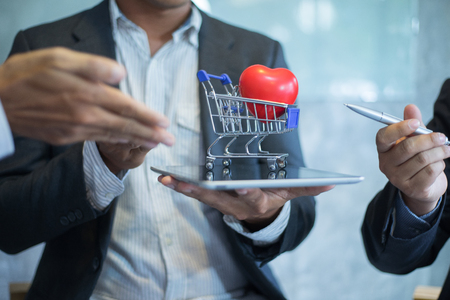 businessman put shopping cart on tablet for sale, shopping conceptの写真素材