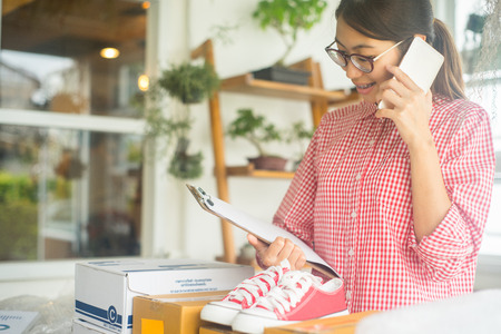 happy women working online business with smartphone in home, online business concept, business owner conceptの写真素材