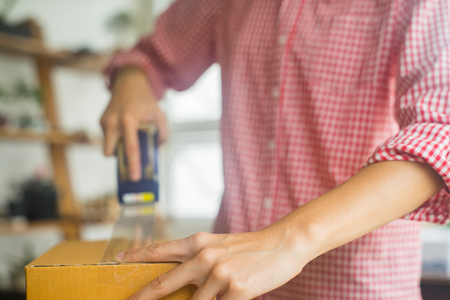 happy women packaging product for online business in home, online business concept, business owner conceptの写真素材