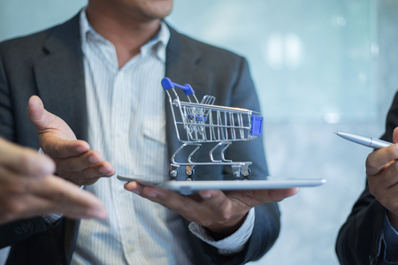 businessman put shopping cart on tablet for sale, shopping conceptの写真素材