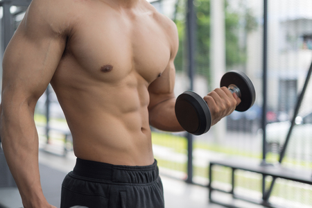 Fitness man in training showing exercises with dumbbells in gym, fitness concept, sport conceptの写真素材