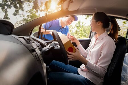 Woman signing receipt on paper from delivery man to get her package, delivery concept