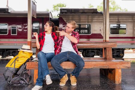Young traveling backpacker on vacation at the train station, travel conceptの写真素材