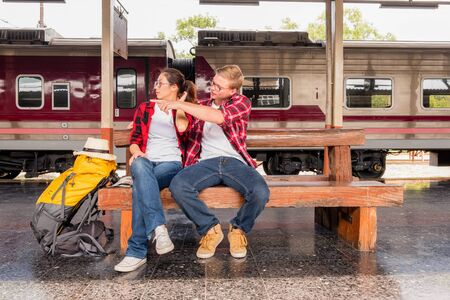 Young traveling backpacker on vacation at the train station, travel conceptの写真素材