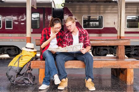 Young traveling backpacker on vacation at the train station, travel conceptの写真素材