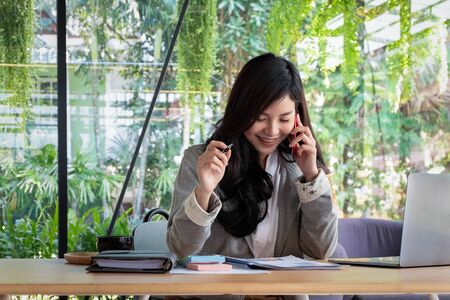 Young businesswoman work with mobile phones and notebooks in the office, business conceptの写真素材