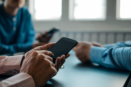 Young business people using smartphone on wooden table share data and send messages in groups, technology conceptの写真素材