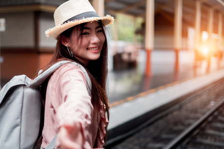 Smiling woman traveler looking camera with backpack on holiday relaxation at the train station,relaxation concept, travel conceptの写真素材