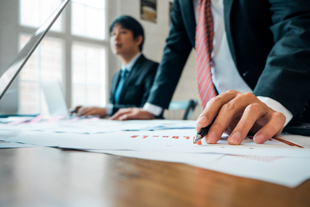 Businesspeople analyzing investment graph meeting brainstorming and discussing plan in meeting room, investment conceptの写真素材