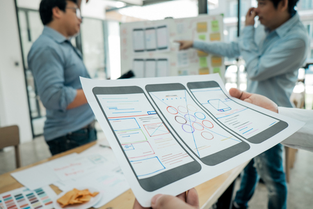 ux graphic designer meeting brainstorming and discussing to sketch smartphone application for web mobile phone, application concept, teamwork conceptの写真素材