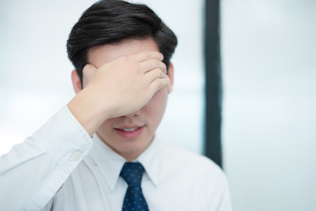 Businessman feel head in their heart while working in the office, medical conceptの写真素材