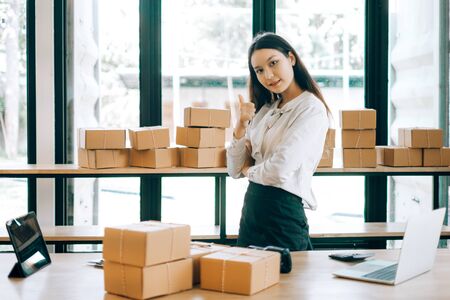 happy women with arms up celebrating for success order online business with laptop in home, online business conceptの写真素材