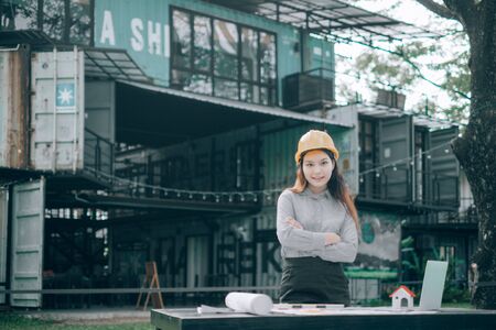 young engineers wearing helmat looking camera outside the office, Engineer concept