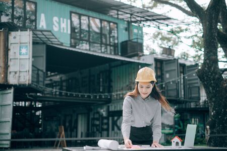 engineers pointing to building on blueprint to drawing design building project outside the office, construction concept. Engineer conceptの写真素材