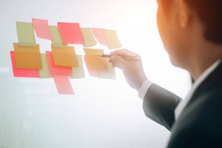 business people sticky notes idea discussing and planning in glass wall at meeting room, teamwork...
