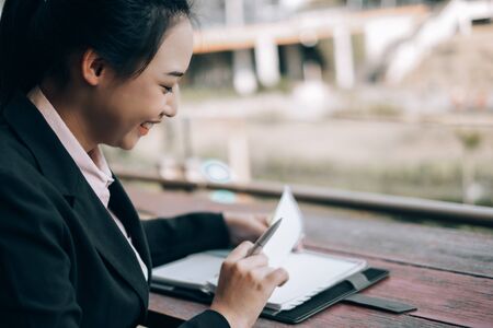 young beautiful businesswoman checking report outside the office, business conceptの写真素材