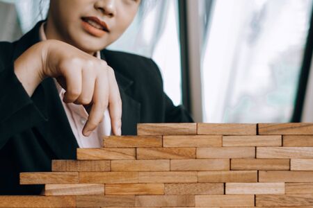 young beautiful businesswoman smiling playing and building wooden at the office, investment conceptの写真素材