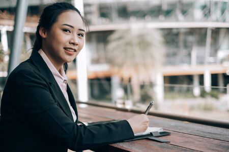 young beautiful businesswoman checking report outside the office, business conceptの写真素材