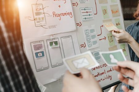 Graphic designers work together with computer designing application for mobile phone, Graphic...