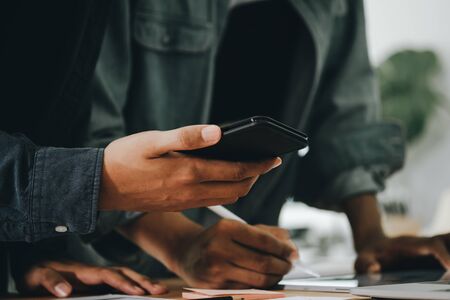 Graphic designers work together with computer designing application for mobile phone, Graphic...