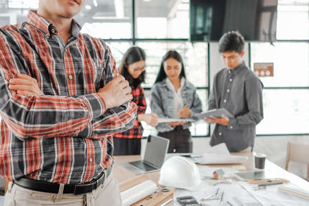 young engineers wearing helmat looking camera in the office, Engineer conceptの写真素材