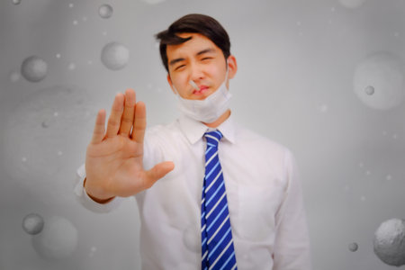 Asian man wear masks  raise your hand to protect PM 2.5 dust and air pollution and headache and sickness, air pollution concept, healthcare concept.の写真素材