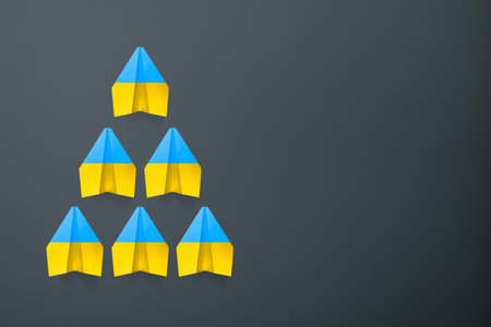 Paper airplane Ukraine flag colors background. flight along the trajectory behind the leader. aid to Ukraineの写真素材