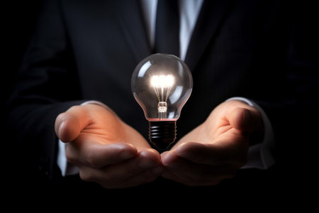 businessman holding a light bulb in his hand. business, ideas, creativity, and innovationの素材