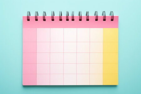 A lively image of a pink and yellow planner set against a vibrant bright blue background. Perfect for organization, creativity, and planning-themed visuals.の素材